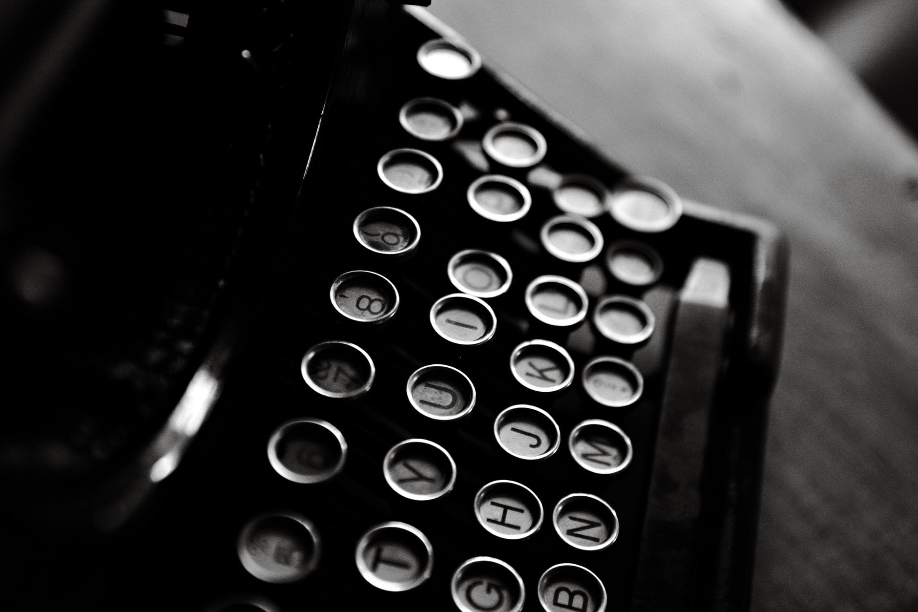 Classic black and white photo of a vintage typewriter showcasing its keys in detail.
