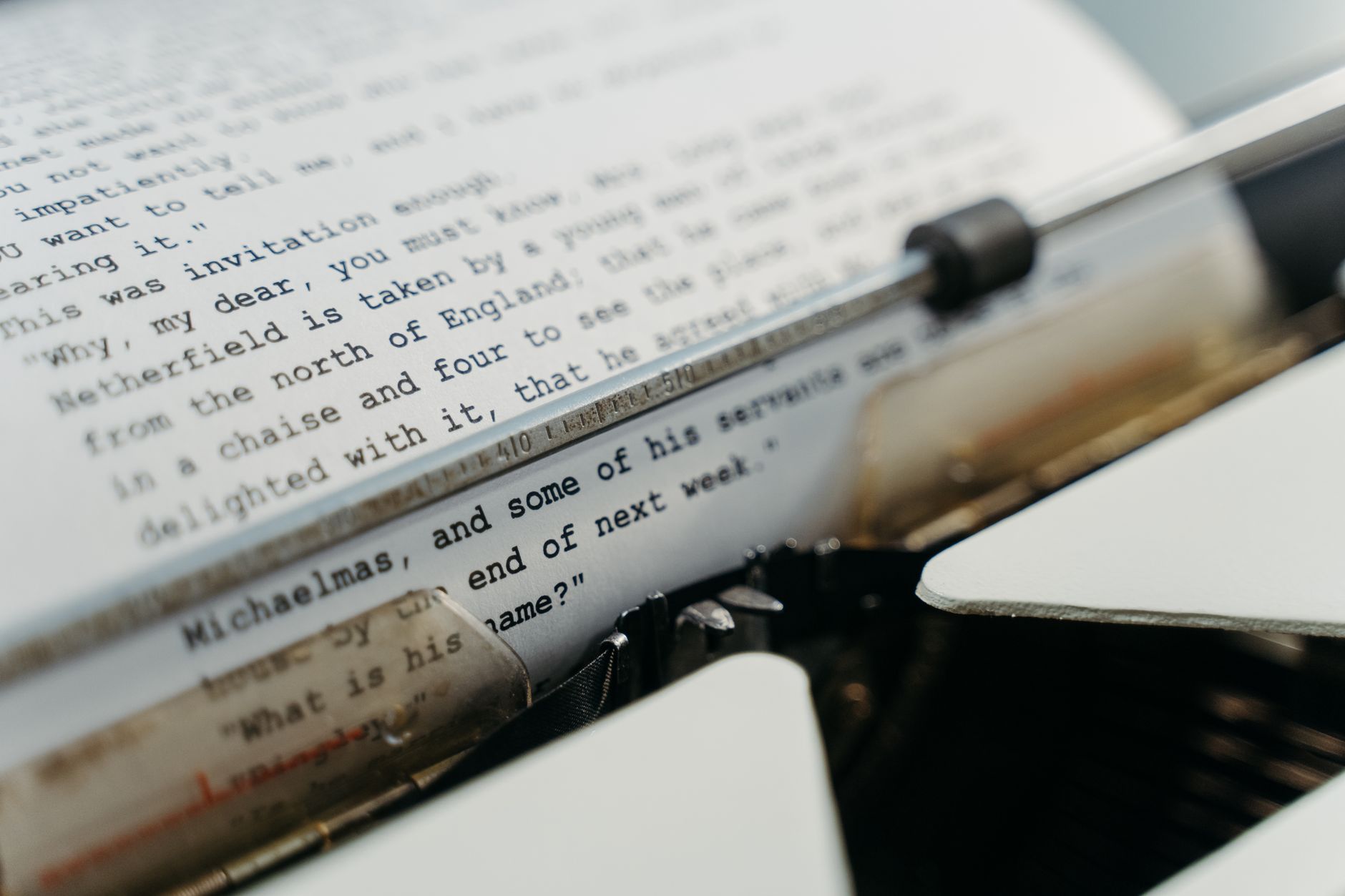 Close-up of a vintage typewriter typing manuscript pages in a classic style.